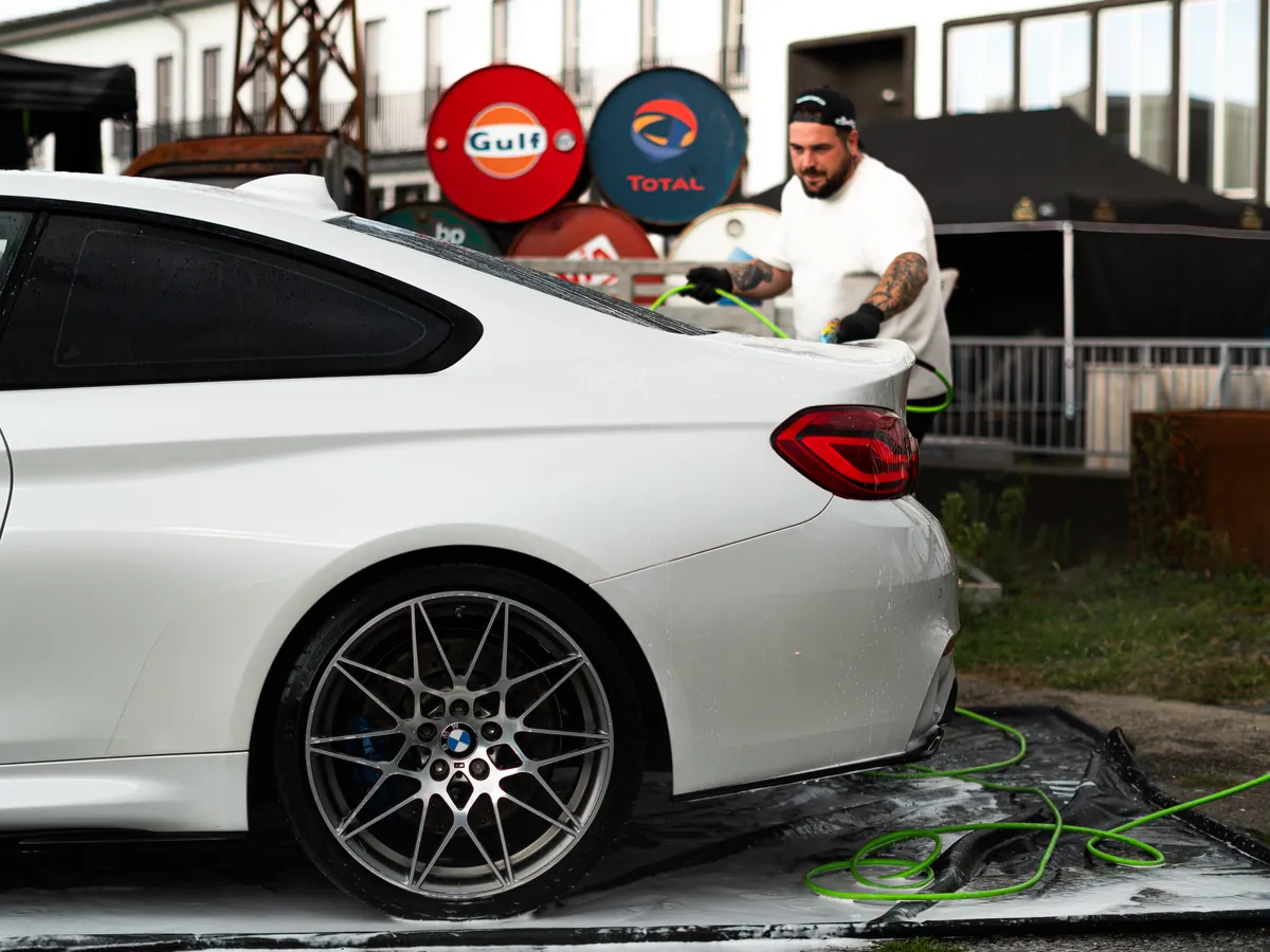 Niklas Wagner bei der Pflege eines weißen BMW